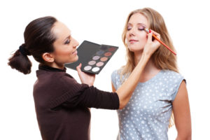 Make-up artist placing eye shadow on woman